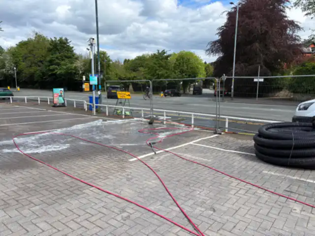 Block paving being pressure washed, foam still on the surface